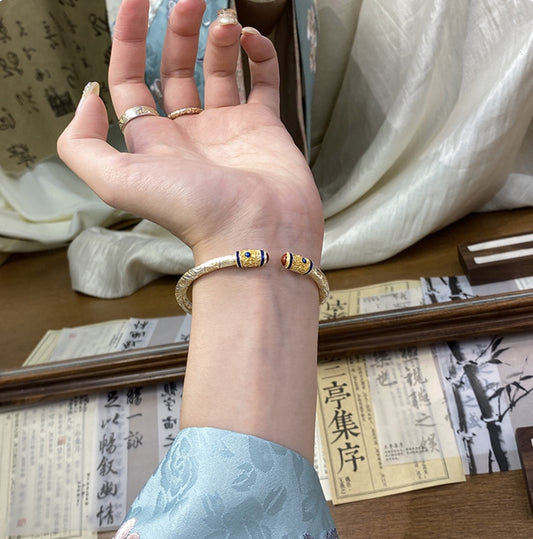A 31g Chinese enamel jewelry bangle featuring palace-style motifs and solid construction. Adjustable open-cuff design with heirloom-level craftsmanship.