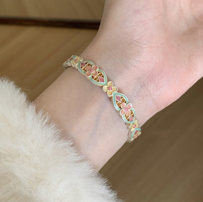 Handcrafted enamel cuff bracelet with hand-colored petals and vintage Chinese bangle design

