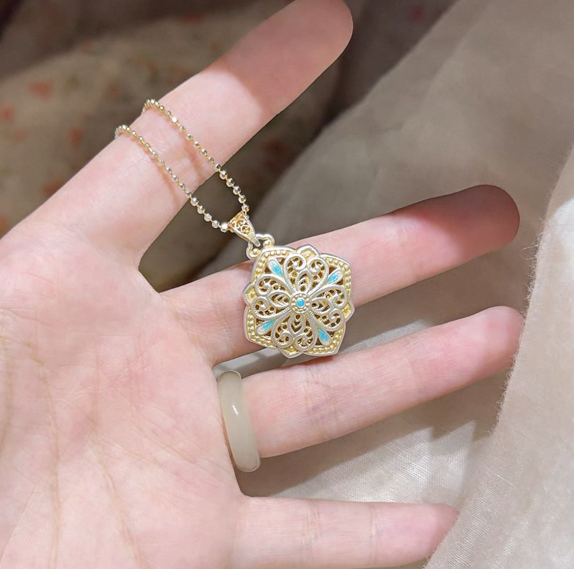 Pendant combining delicate hollow silverwork with smooth enamel — a balanced piece of Chinese enamel jewelry suitable for layering or gifting.
